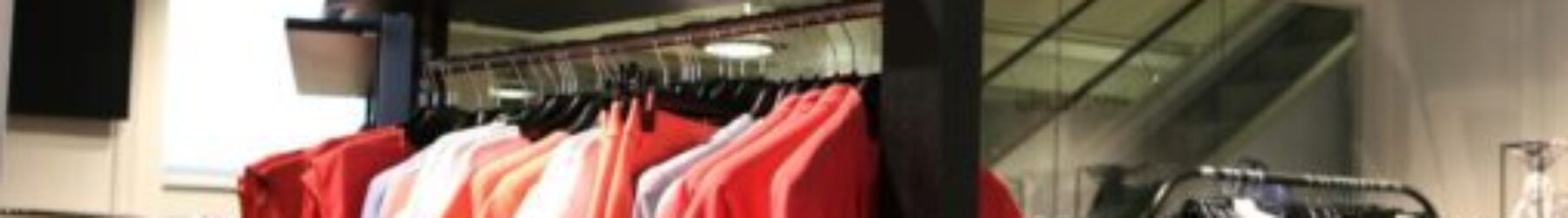 Discover a chic fashion boutique showcasing a variety of colorful clothes on elegant racks.